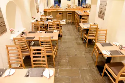 an empty restaurant with wooden tables and chairs at Sandyford Hotel in Glasgow