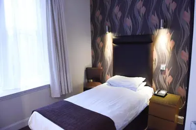 a bedroom with a bed and a wall with hearts at Sandyford Hotel in Glasgow