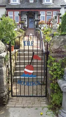 a gate with two chairs on it in front of a house at The Moorings in Tarbert