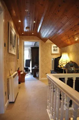 a hallway with a staircase and a living room at The Moorings in Tarbert