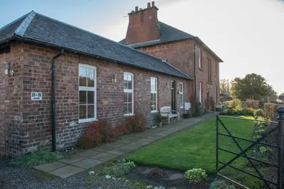 an old brick building with a gate in front of it at Ashbank Bed & Breakfast in Drymen