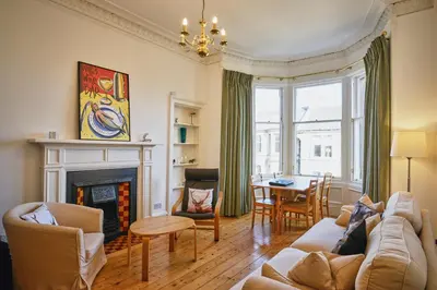 a living room with a couch and a fireplace at Comely Bank Apartment in Edinburgh