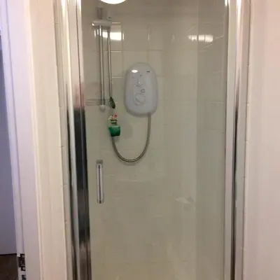 a shower in a bathroom with a controller on the wall at Starfish Rooms in Tarbert