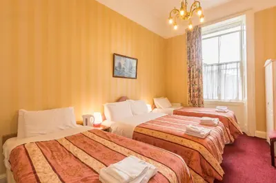 a hotel room with two beds and a window at Menzies Guest House in Edinburgh