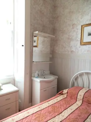 a bedroom with a bed and a sink and a mirror at Menzies Guest House in Edinburgh