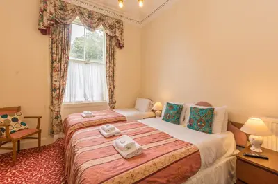 a bedroom with two beds and a window at Menzies Guest House in Edinburgh