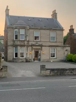 a large brick house with a driveway in front of it at Braidmead House in Irvine