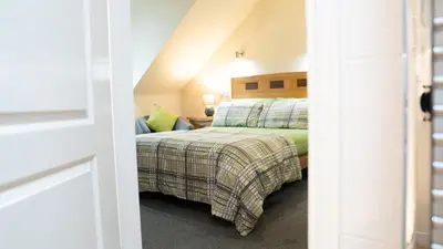 a bedroom with a bed in a attic at Braidmead House in Irvine
