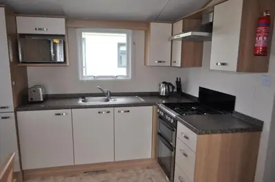 a small kitchen with white cabinets and a sink at Bellochantuy Beach in Bellochantuy