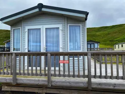a small house on a porch with a railing at Bellochantuy Beach in Bellochantuy