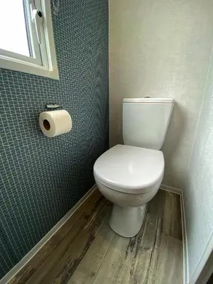 a bathroom with a toilet and a roll of toilet paper at Bellochantuy Beach in Bellochantuy