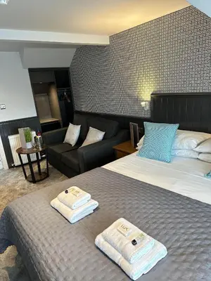 a hotel room with a bed and a couch at Nithsdale Hotel in Sanquhar