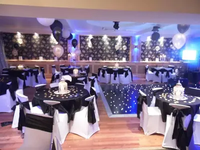 a banquet hall with black and white tables and chairs at Nithsdale Hotel in Sanquhar