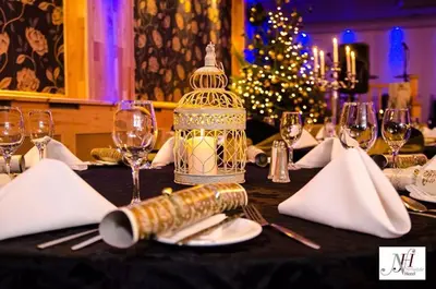 a table with a bird cage on a table with wine glasses at Nithsdale Hotel in Sanquhar