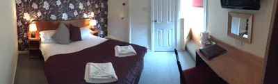 a hotel room with a bed with towels on it at Nithsdale Hotel in Sanquhar