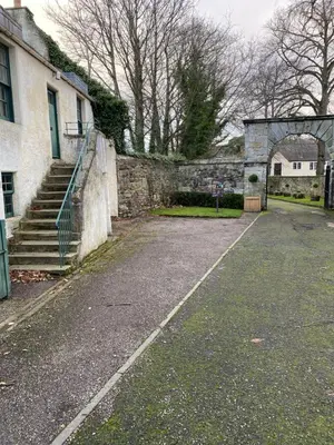 an empty street in front of a stone building at Sea Hollies in Aberdour