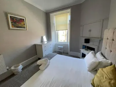 a bedroom with a large white bed and a window at Apartment 2 Bed West End in Glasgow