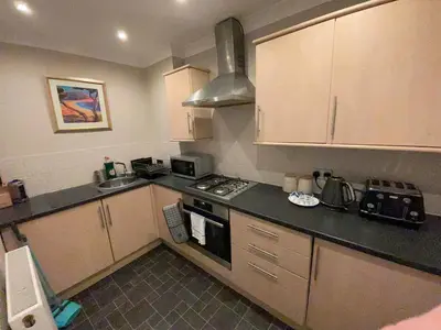 a small kitchen with a stove and a sink at Apartment 2 Bed West End in Glasgow