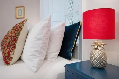 a room with a bed with pillows and a red lamp at East Lodge in Crieff