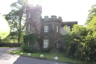 an old stone house with rocks in front of it at East Lodge in Crieff
