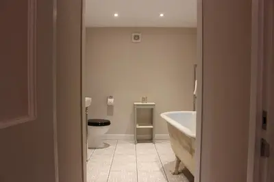 a bathroom with a tub and a toilet and a sink at East Lodge in Crieff
