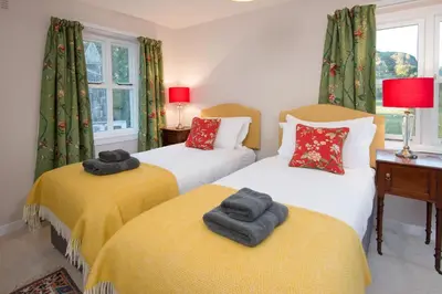 a bedroom with two beds with towels on them at East Lodge in Crieff