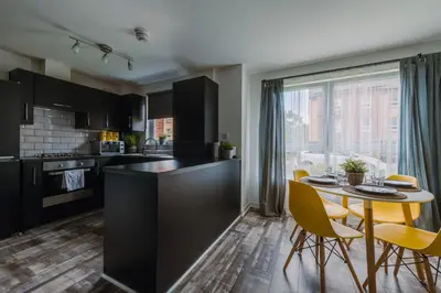 a kitchen and dining room with a table and chairs at SuperbSleep Apartments in Glasgow