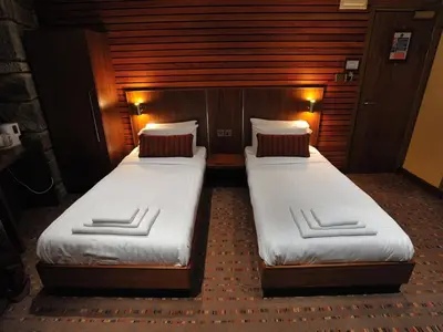 two beds in a small room with two at The Commercial Hotel in Wishaw
