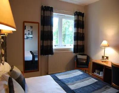 a hotel room with a bed and a window at The Tontine Hotel in Greenock