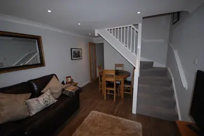 a living room with a couch and a staircase at The Beeches at Gleneagles in Auchterarder