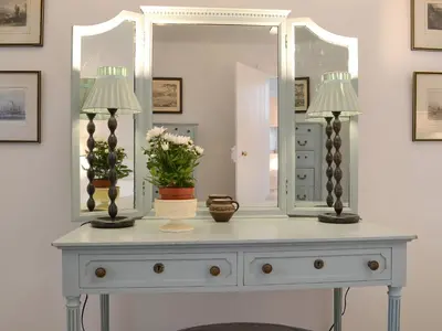 a white dresser with two lamps and a mirror at Garden Cottage in Strachur
