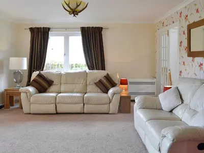 a living room with a white couch and a window at River Mill House in Ballachulish
