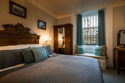 a bedroom with a large bed and a window at The Alamo Guest House in Glasgow