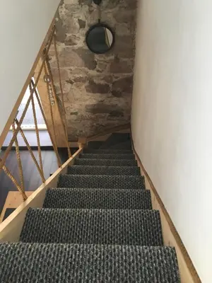 a staircase in a room with a stone wall at Ayrshire Holiday Cottage in Girvan