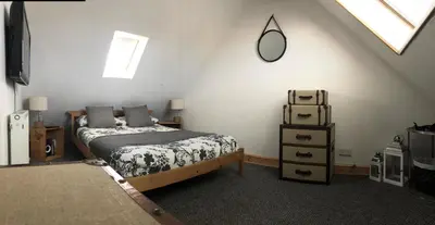a bedroom with a bed and a mirror on the wall at Ayrshire Holiday Cottage in Girvan