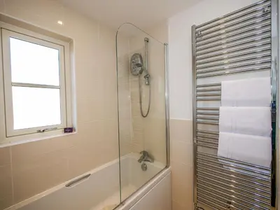 a bathroom with a shower and a tub and a sink at Holiday Home Devonvale Place by Interhome in Kinross