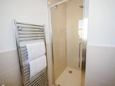 a shower with white towels in a bathroom at Holiday Home Devonvale Place by Interhome in Kinross