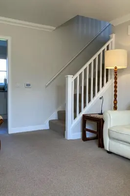 a living room with a staircase and a couch at Holiday Home Devonvale Place by Interhome in Kinross