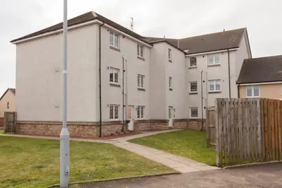a large white building with a fence in front of it at Dunfermline - Luxury Two Bedroom Apartment - TP in Dunfermline