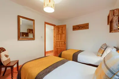 a bedroom with two beds and a mirror at Dundas Flat, 1 bedroom, Comrie in Comrie