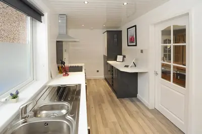 a kitchen with a stainless steel sink and a window at Three Bedroom Spacious House in Stirling