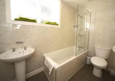 a bathroom with a sink and a toilet and a shower at Ivybank Cottage in Lochgoilhead