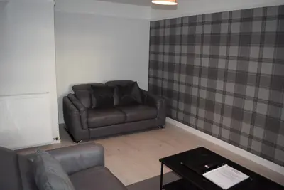 a living room with a leather couch and a table at 3 Bedroom-Kelpies Serviced Apartments Burns in Falkirk
