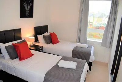 a hotel room with two beds and a window at Kelpies Serviced Apartments MacGregor- 2 Bedrooms in Grangemouth