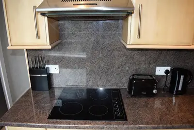 a kitchen counter top with a stove top oven at Kelpies Serviced Apartments MacGregor- 2 Bedrooms in Grangemouth