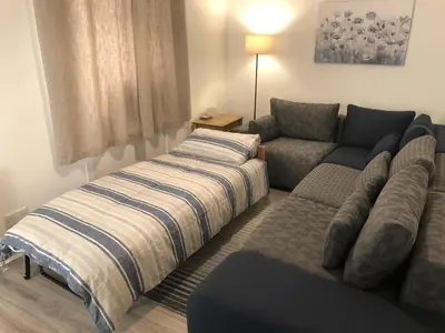 a living room with a bed and a couch at Garden Gate Upper Apartment in Prestwick