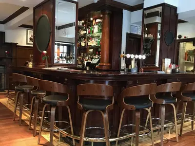 a bar with a bunch of stools in a room at Rab Ha's in Glasgow