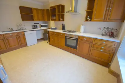 a kitchen with wooden cabinets and white appliances at Ashburn Cottage in Lochgoilhead