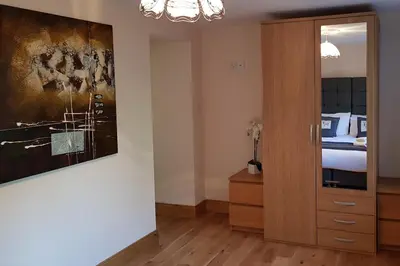 a bedroom with a bed and a wooden cabinet at Ashburn Cottage in Lochgoilhead
