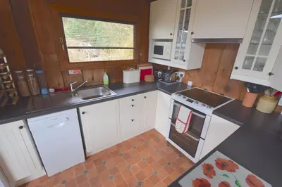 a kitchen with white cabinets and a sink at Dalriada by Loch Goil in Carrick